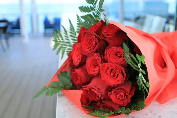 Bouquet de rosas rojas envuelto en papel rojo
