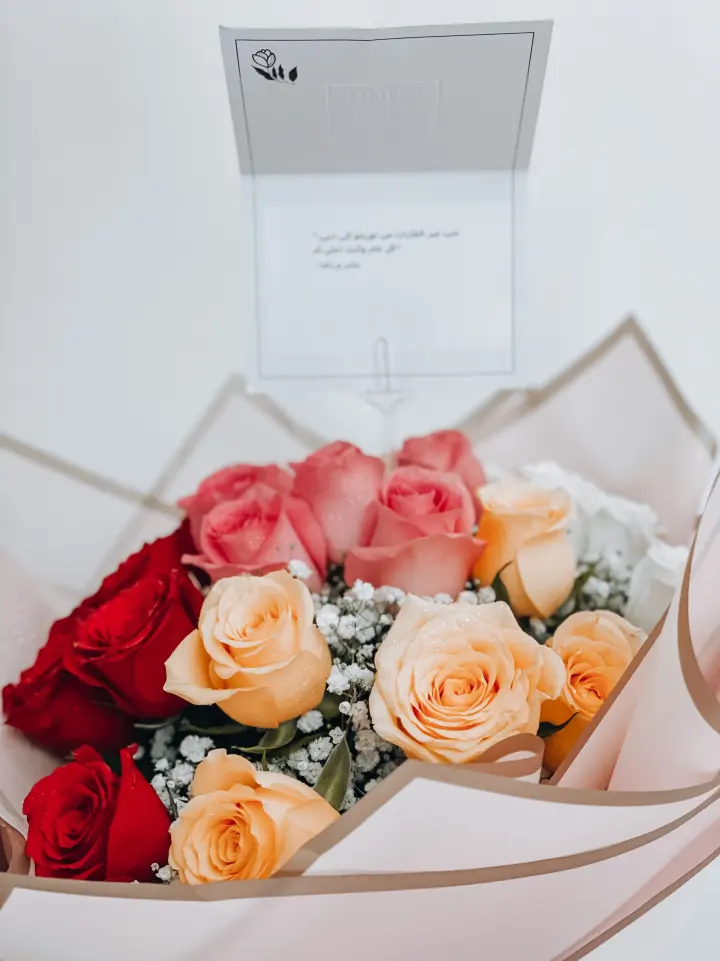 Bouquet de rosas rojas y durazno con una tarjeta