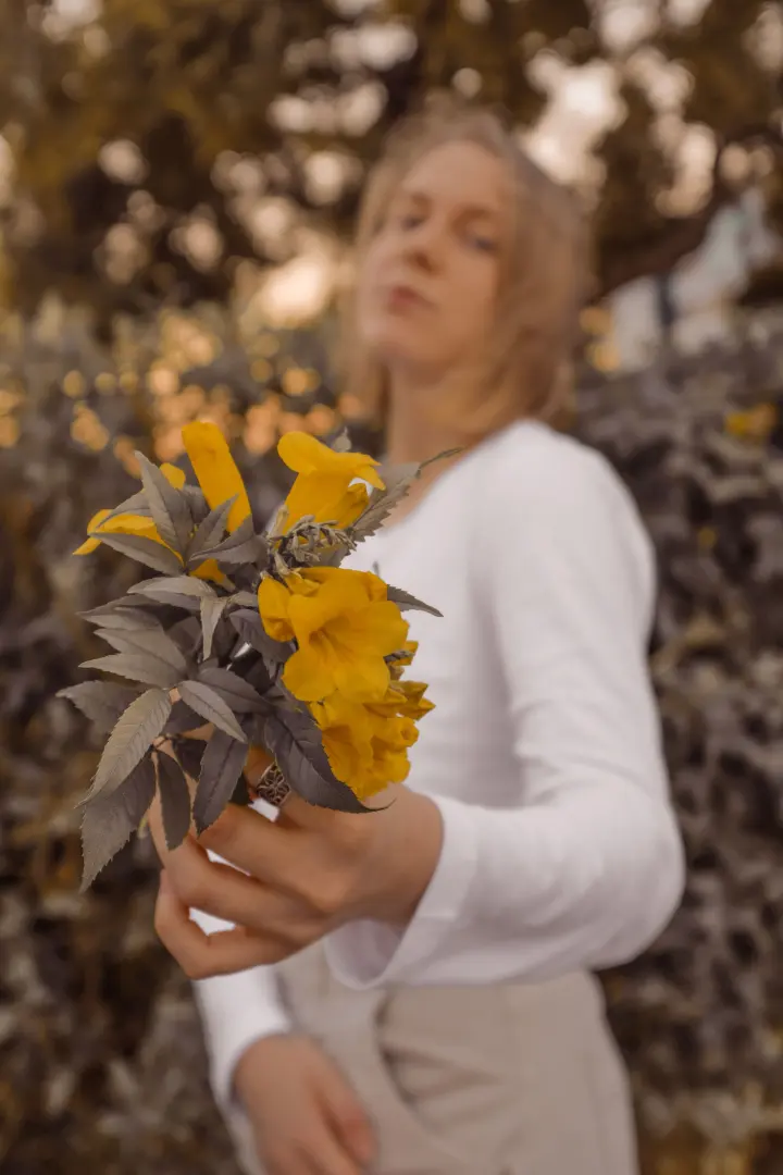 Mujer sosteniendo flores amarillas
