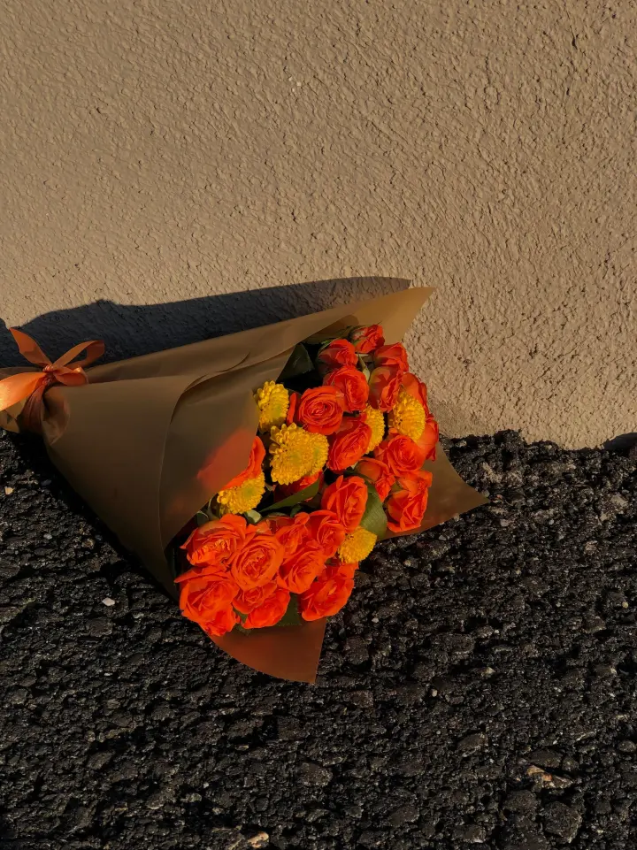 Bouquet Golden Hour: rosas naranjas y amarillas en papel kraft
